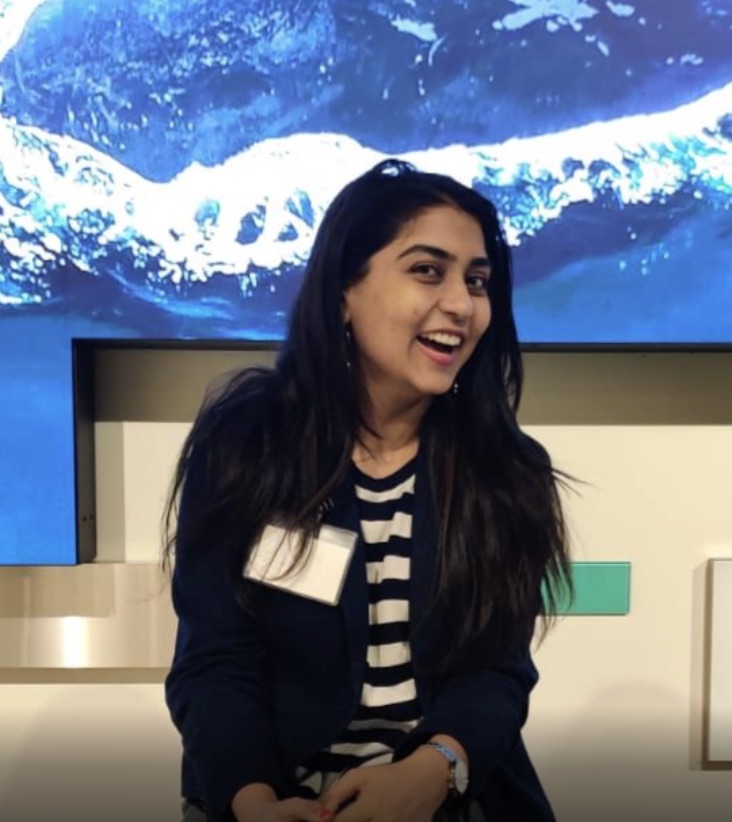 Ishita Thanki smiling in front of an Earth display